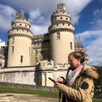 Visiteuse avec un audioguide devant le château de Pierrefonds