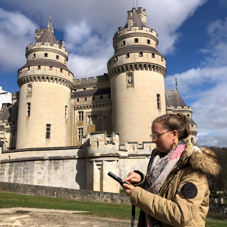 Visiteuse avec un audioguide devant le château de Pierrefonds